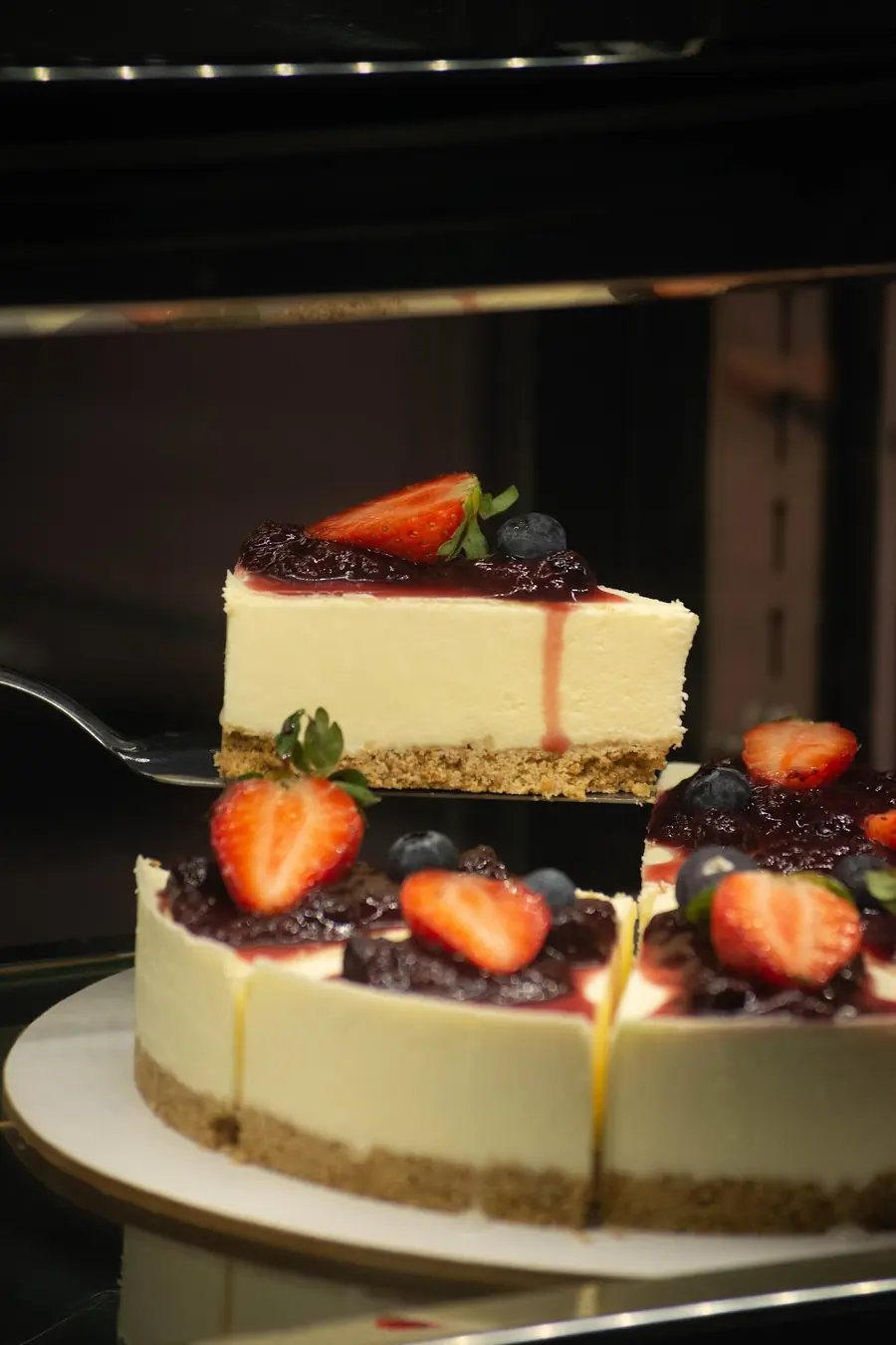 Porción de cheesecake con frutilla y arándanos