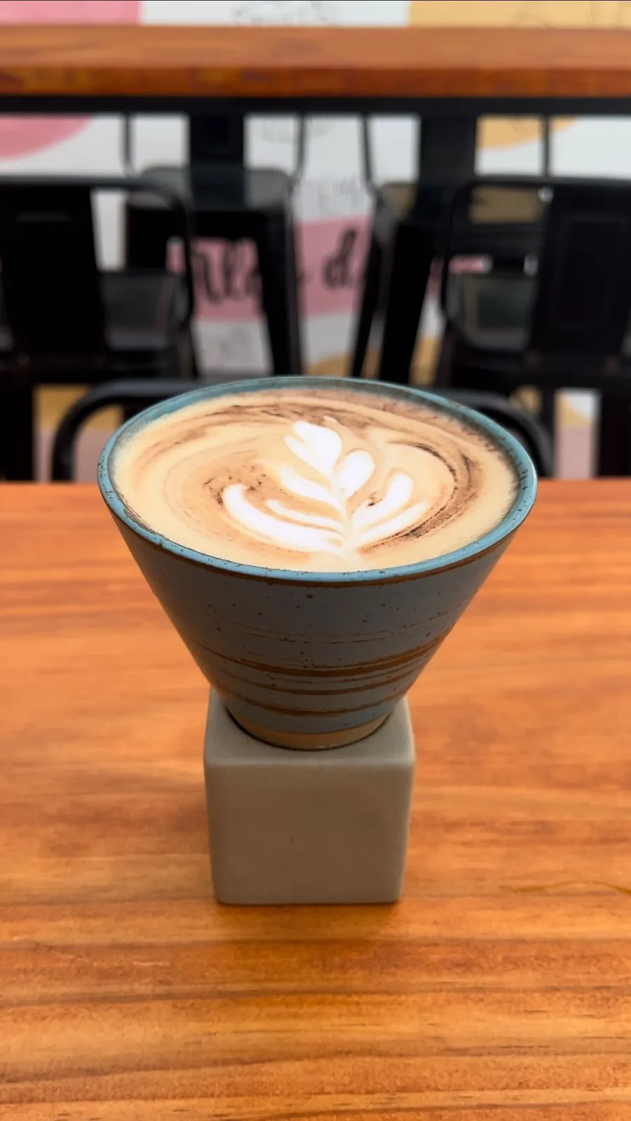 Café con latte art de hojas en una taza de cerámica azul